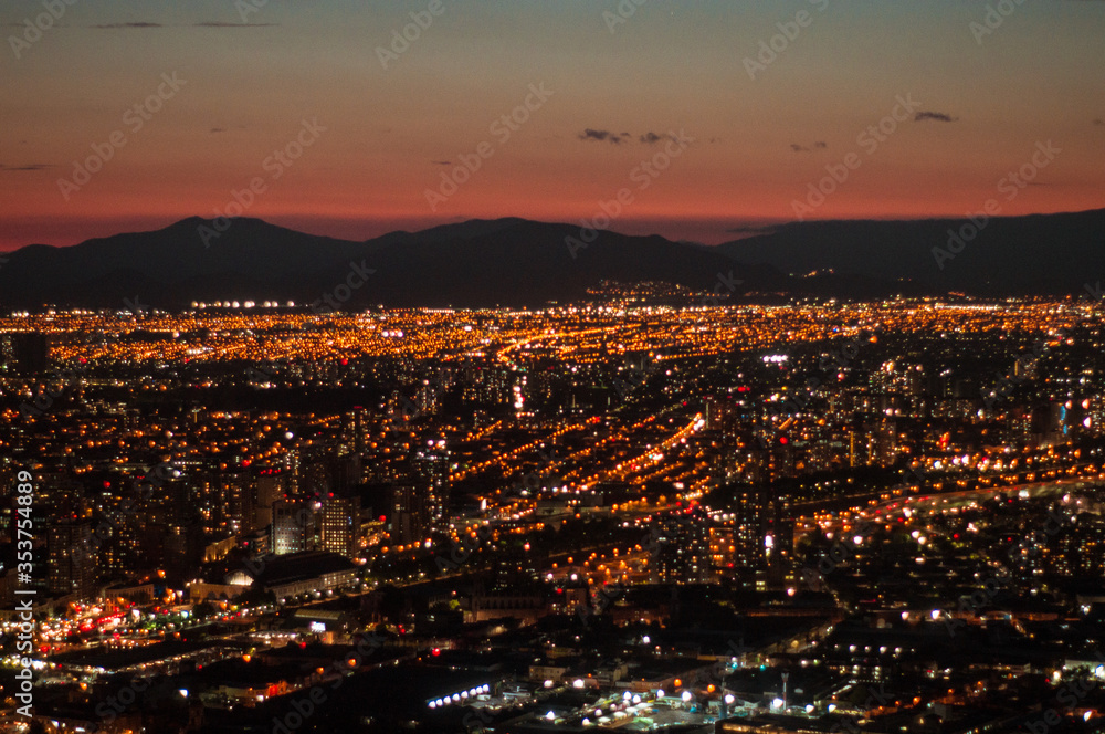 Ciudad de noche con luces encendidas entre montañas