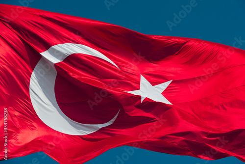 Turkish flag waving in blue sky.