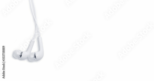 A pair of white headphones in a hanging position isolated on a white background.