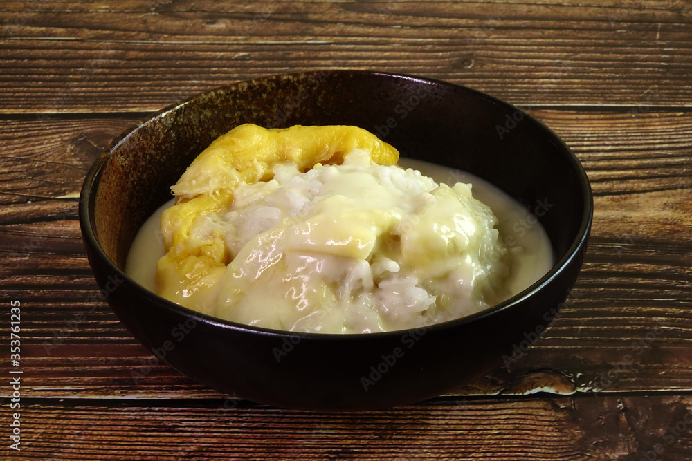 Durian sticky rice in coconut milk and durian creamy sauce. One of most famous Thai dessert in summer of durian season. Selective focus Durian sticky rice in coconut milk and durian creamy sauce. One of most famous Thai dessert in summer of durian season. Selective focus