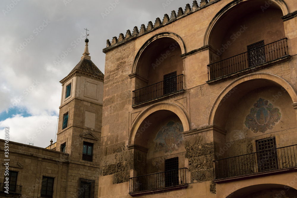 Church in Cordoba Spain  Big arches and windows.  Red hot stone walls.  Cloudy skies.  Moody image.