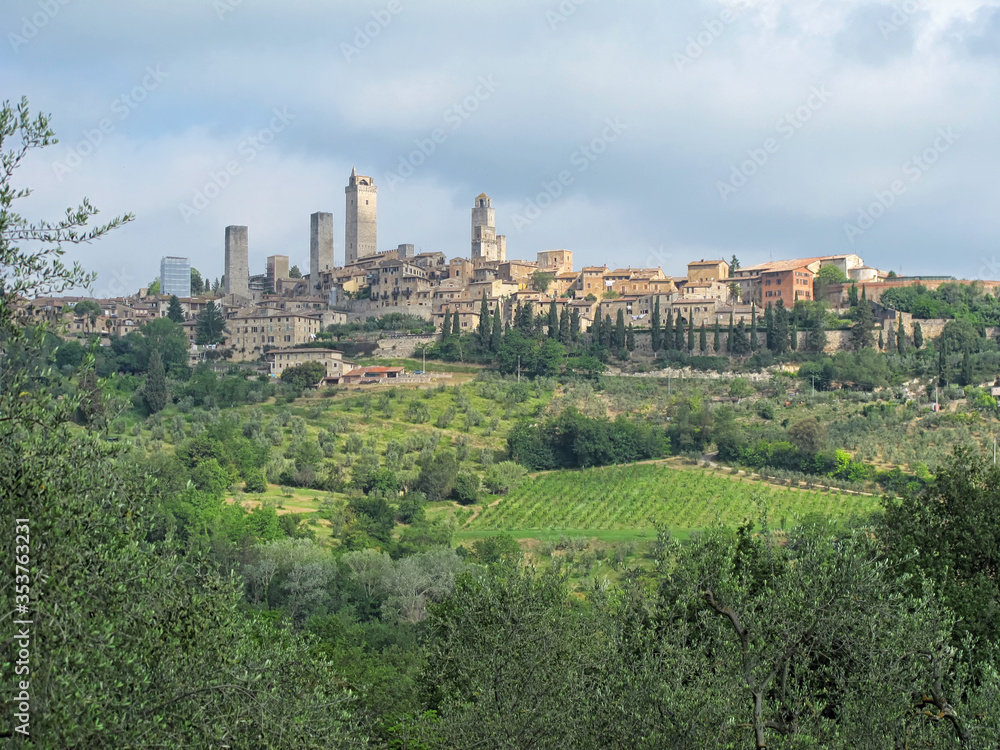 Cityscape Showing the Medieval Towers of San Giminano, ItalyThe Medieval towers of San Gimignano rise above the cityscape and hills of Tuscany, Italy, surrounded by olive groves and vineyards.