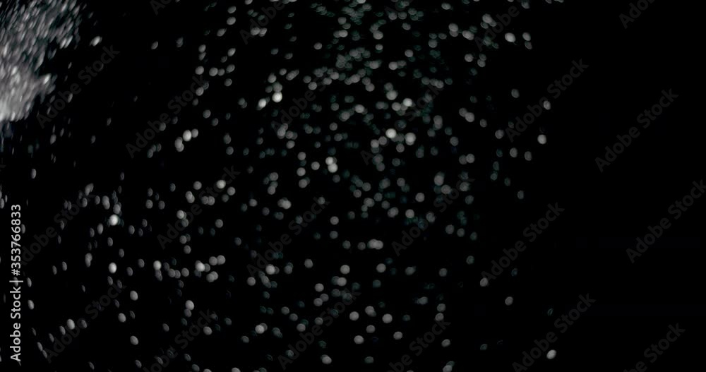 Snowflakes floating in the air slowly at night. It shows the white particles dropping from above slowly against the isolated black background. Snowflakes floating in the air slowly at night. It shows the white particles dropping from above slowly against the isolated black background.