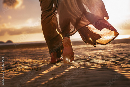 Fototapeta Naklejka Na Ścianę i Meble -  close up of woman feet walking onthe beach at sunset