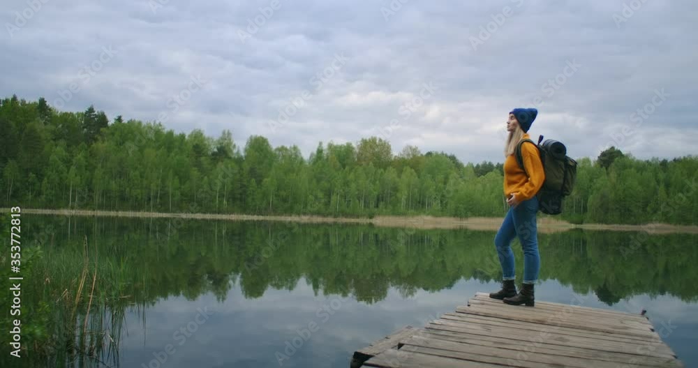 Portrait of a young female traveler on the lake in slow motion. Look at the beauty of the forest lake Portrait of a young female traveler on the lake in slow motion. Look at the beauty of the forest lake