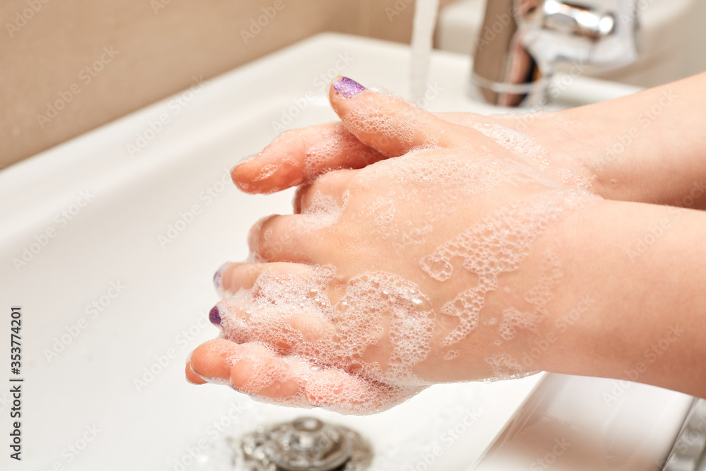 White Child Washing Hands with Soap and Running Water over Sink White Child Washing Hands with Soap and Running Water over Sink