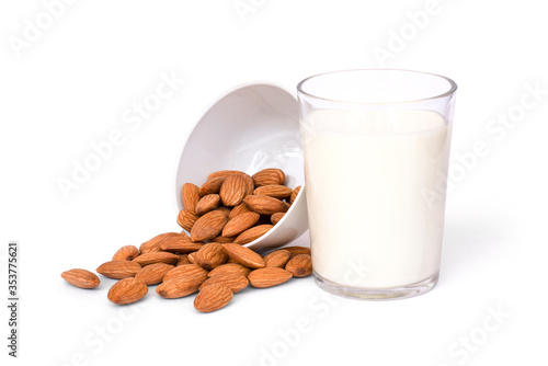 Glass of Almond milk and almond seeds in wooden bowl isolated on white background. Healthy drinks concept. 