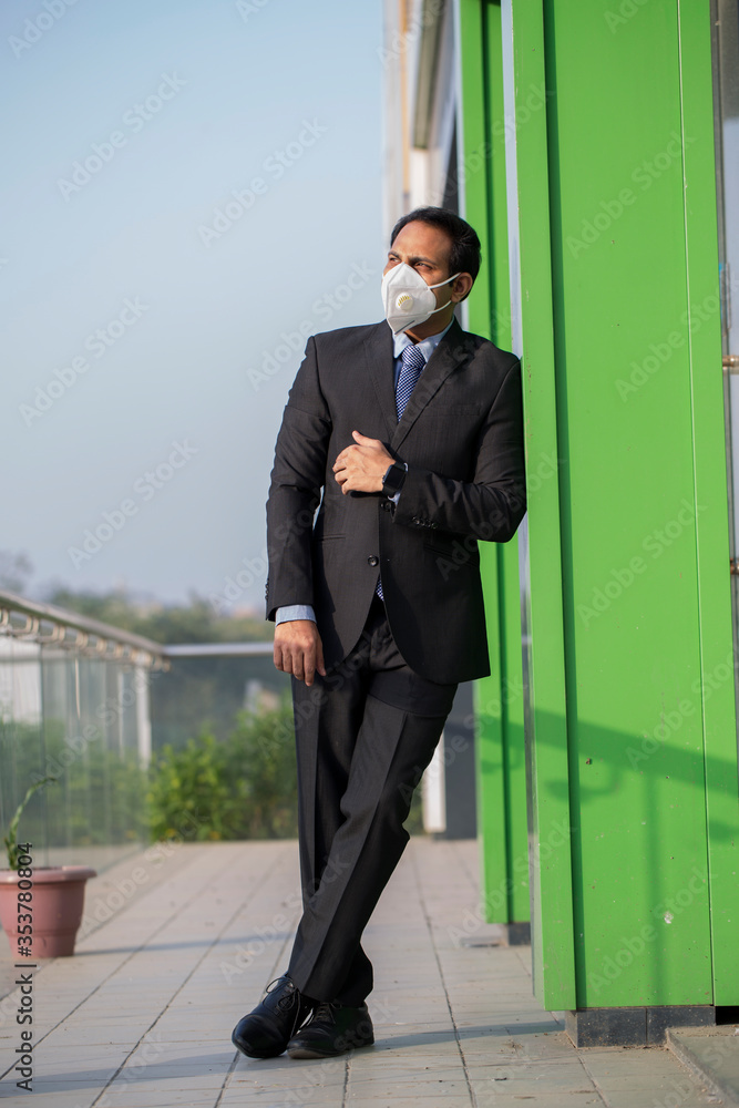Businessman wearing mask in the outside office for safety during pandemic Businessman wearing mask in the outside office for safety during pandemic