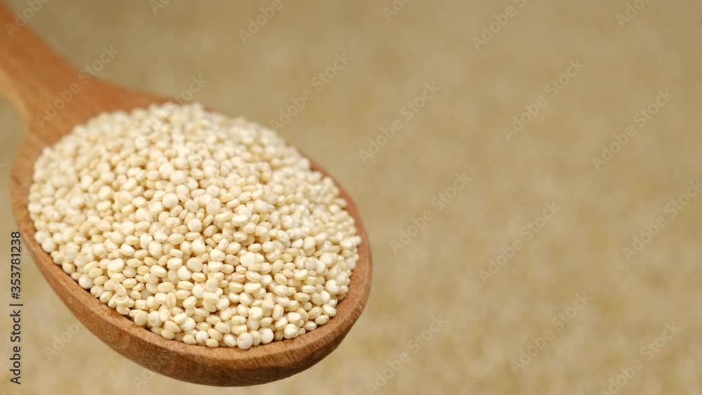 quinoa seeds in wooden spoon and on background rotating. top view quinoa seeds in wooden spoon and on background rotating. top view
