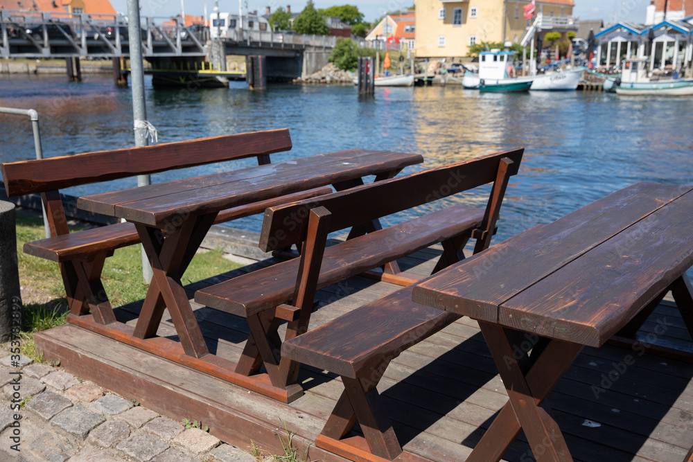 old picnic bench sitting out to the canal with view of boats