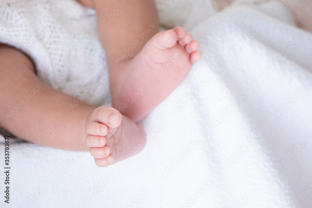 Selective focus tiny newborn baby girl or boy feet and toes in warm good quality textile blanket , adorable sleep on white bed with safe at home or hospital Selective focus tiny newborn baby girl or boy feet and toes in warm good quality textile blanket , adorable sleep on white bed with safe at home or hospital