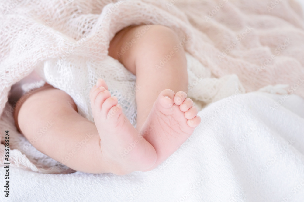 Selective focus tiny newborn baby girl or boy feet and toes in warm good quality textile blanket , adorable sleep on white bed with safe at home or hospital Selective focus tiny newborn baby girl or boy feet and toes in warm good quality textile blanket , adorable sleep on white bed with safe at home or hospital