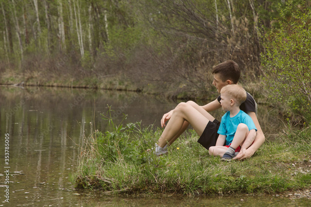 Children on a river in a forest catch fish Children on a river in a forest catch fish