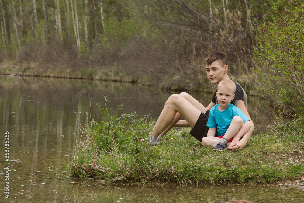 Children on a river in a forest catch fish Children on a river in a forest catch fish