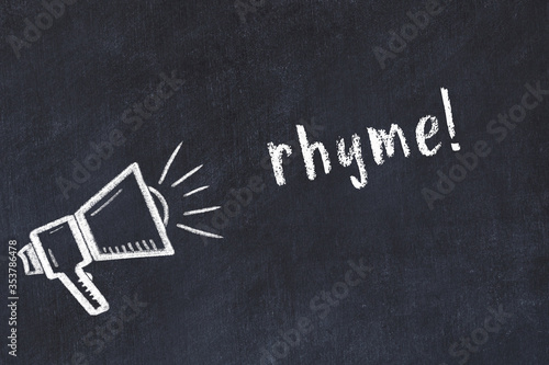 Foto Chalk loudspeaker and inscription rhyme on black chalkboard