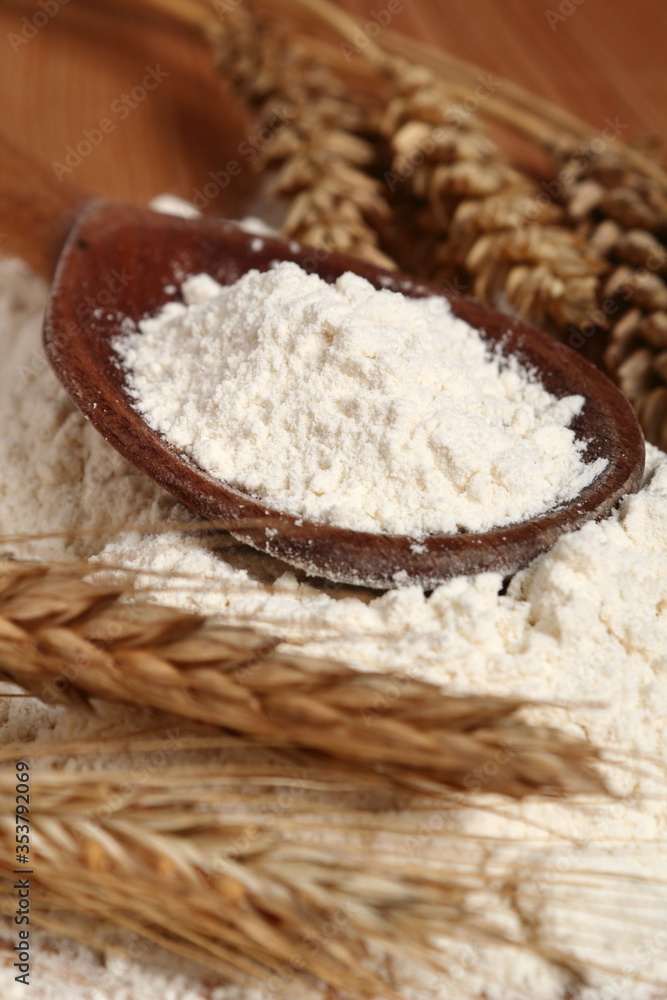 Wooden spoon with flour and wheat ears Wooden spoon with flour and wheat ears