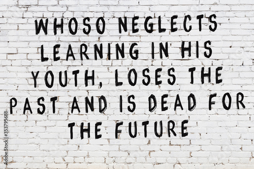 White brick wall with painted black inscription of wise quote photo