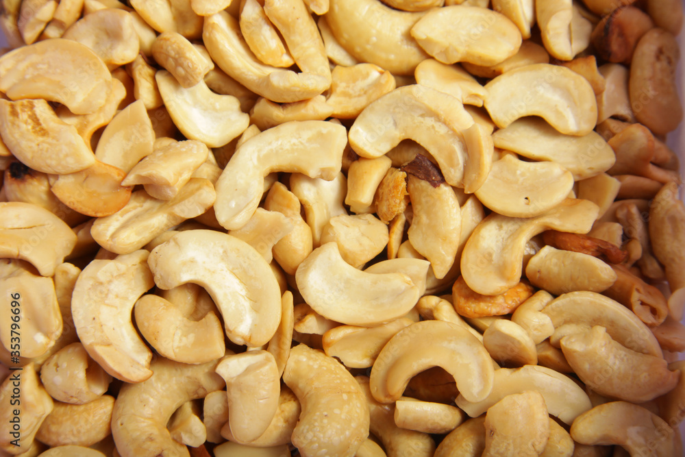 Fried splited cashews on a wooden table, a tasteful snack Fried splited cashews on a wooden table, a tasteful snack