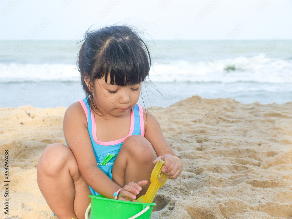 happy Asian girl playing with toy and sand at the beach
happy Asian girl playing with toy and sand at the beach