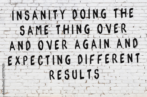 White brick wall with painted black inscription of wise quote