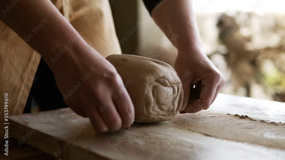 Unrecognizable woman cutting the clay before begin sculpting close-up in workshop. Making ceramic products. Artistic creative. Sculptor sculpts pots products. Master crock. Potter's work close-up Unrecognizable woman cutting the clay before begin sculpting close-up in workshop. Making ceramic products. Artistic creative. Sculptor sculpts pots products. Master crock. Potter's work close-up