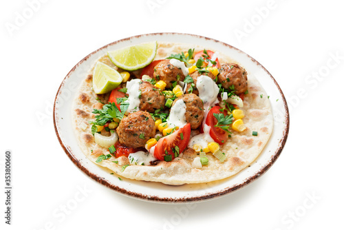 Tortilla with grilled meatball, corn and fresh salad. isolated on white background