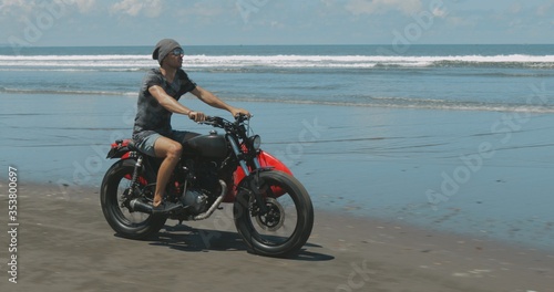 Motorcyclist driving his motorbike on the beach
