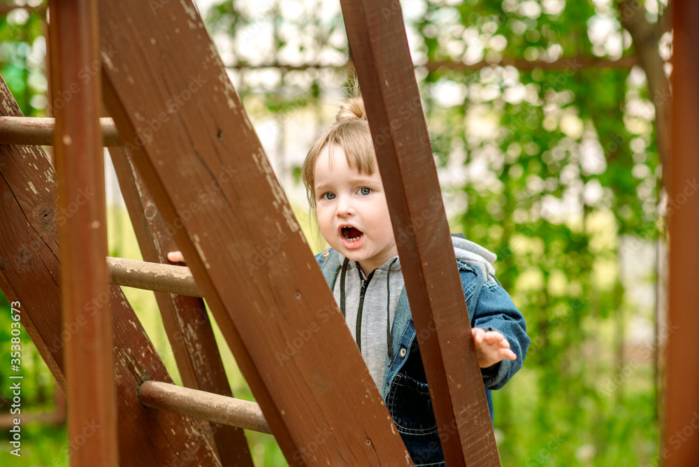 happy little toddler girl on the playground.Children's games in the park outdoors.Childhood joy and happiness.cheated, emotion perplexed.kids in kindergarten for a walk happy little toddler girl on the playground.Children's games in the park outdoors.Childhood joy and happiness.cheated, emotion perplexed.kids in kindergarten for a walk