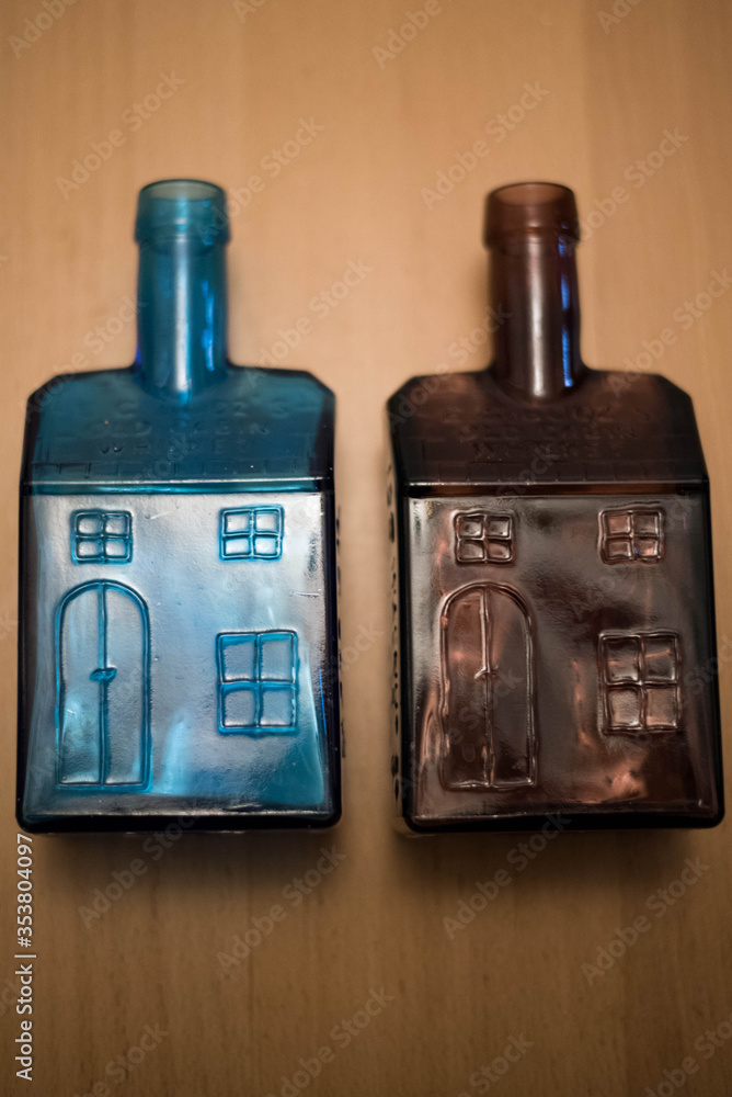 Naklejka premium Wheaton Collectible Vintage Brown and Blue Glass Old Cabin Whiskey Bottles
