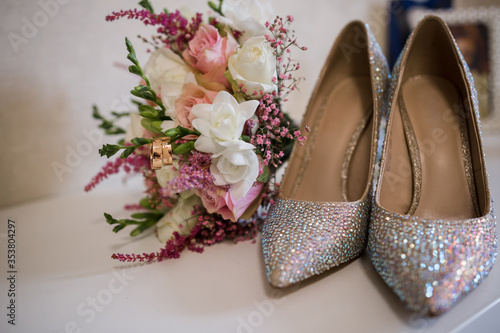 Fototapeta Naklejka Na Ścianę i Meble -  wedding gold rings with bride shoes and decor