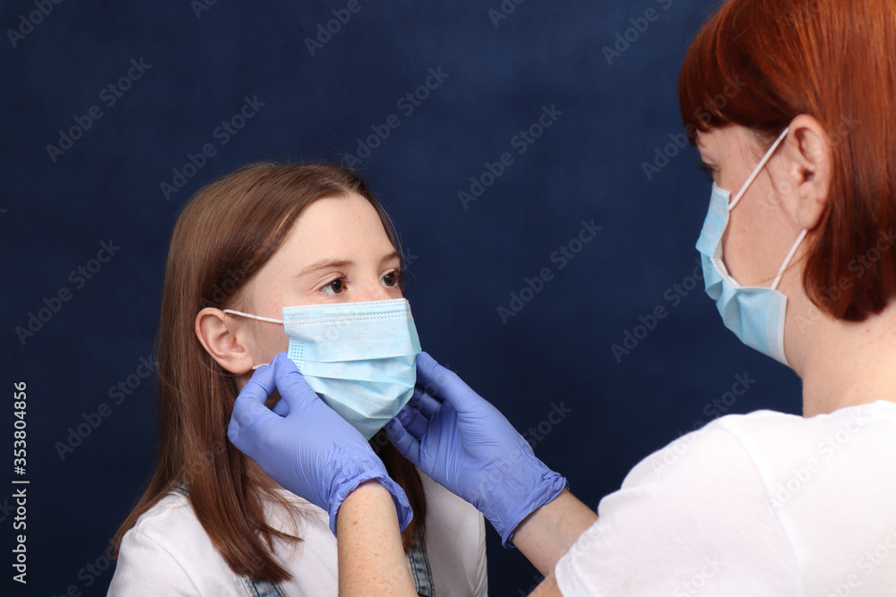 Mother dresses daughter protective medical masks. The concept of protection from viruses and disease. Corona virus Pandemic 2019