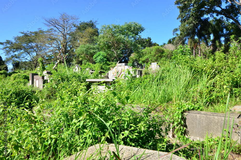Tombstones On Grassy Field In Cemetery Against Sky Tombstones On Grassy Field In Cemetery Against Sky