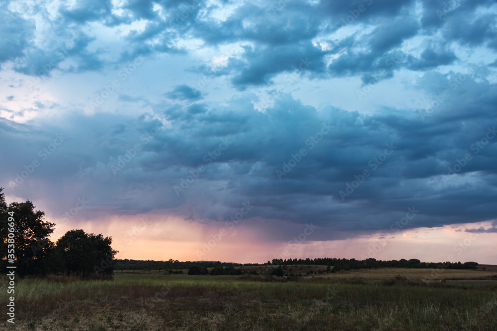 Landscape of a plain with a thunderstorm coming and thunderclouds in the overcast sky