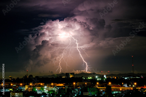 Cloudy with Bright lightning bolt strikes in the rural landscape of small city and satellite station