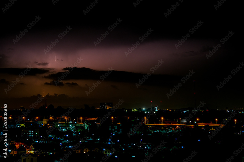 Cloudy with Bright lightning bolt strikes in the rural landscape of small city and satellite station