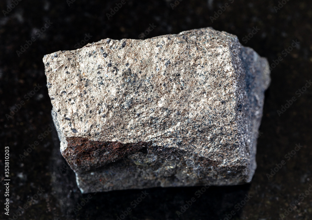 closeup of sample of natural mineral from geological collection - unpolished Pyrrhotite (Pyrotite) rock on black granite background from Kola Peninsula, Russia closeup of sample of natural mineral from geological collection - unpolished Pyrrhotite (Pyrotite) rock on black granite background from Kola Peninsula, Russia