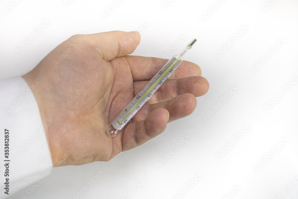 Thermometer in hand on a light background Thermometer in hand on a light background
