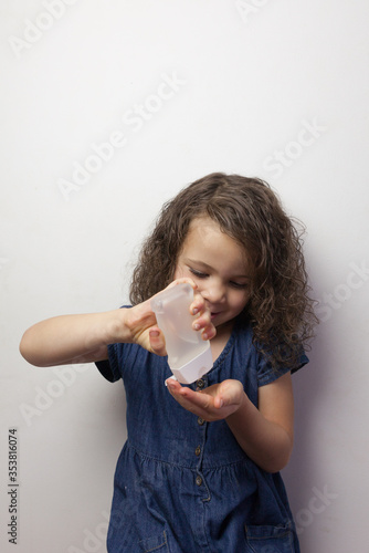 young girl using sanitizer hand gel 