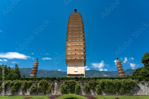 The Three Pagodas of Chongsheng Temple near Dali Old Town, Yunnan province, China. Scenic mountains are visible in background. Ancient pagodas are a popular tourist destination of Asia. 
