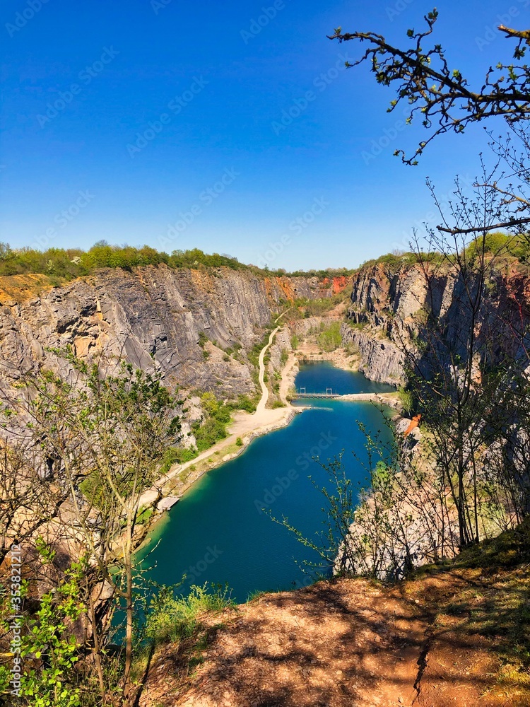 Czech Grand Canyon from View Point in Central Bohemian Region. Big America With the View of Turquoise Lake and Limestone Quarry During Golden Hour Before Sunset. Czech Grand Canyon from View Point in Central Bohemian Region. Big America With the View of Turquoise Lake and Limestone Quarry During Golden Hour Before Sunset.