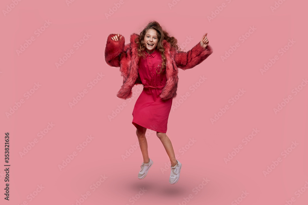 Beautiful young girl dancing and jumping in a pink coat. Clothing style. Beautiful young girl dancing and jumping in a pink coat. Clothing style.