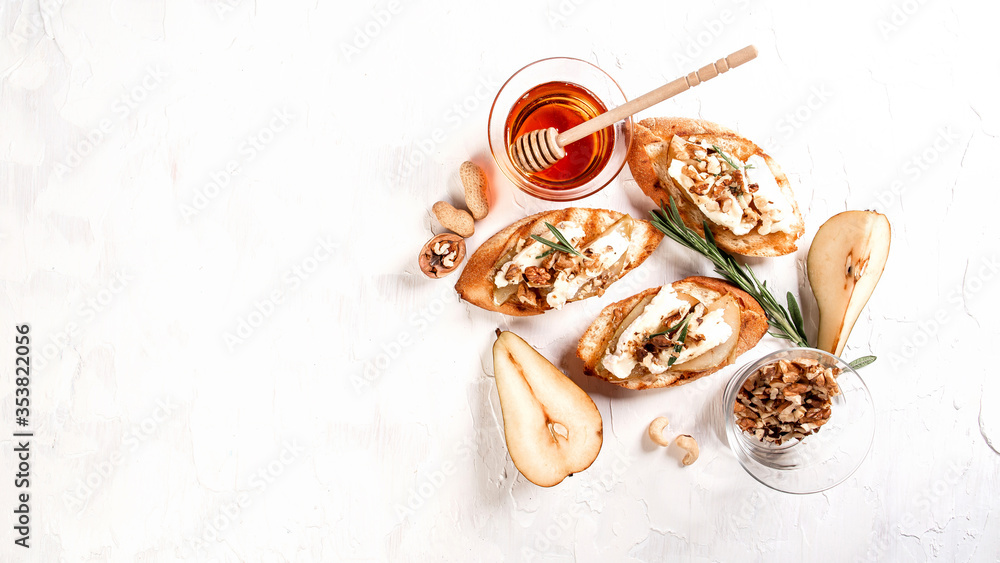 Toast with cheese, pear, honey and nuts. Delicious breakfast or snack with brie camembert cheese on a light background, top view