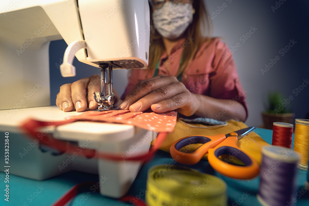 Close up Latin female hands sewing with sew machine homemade medical face  mask for preventing and stop corona virus spreading - textile industry and  covid19 healthcare concept Stock Photo