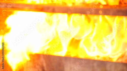 The Coals are Smoldering in the Barbecue. The Cook Adds Lighter Fluid on the Hot Coals. Coals Flare Brightly in Josper Grill.