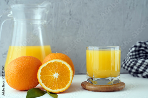 glass of fresh orange juice on the table with a napkin and a jug