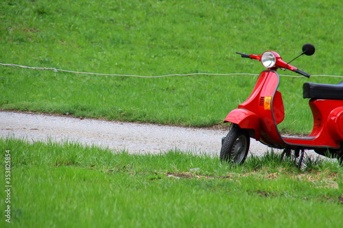 red motorcycle stands in the meadow  photo