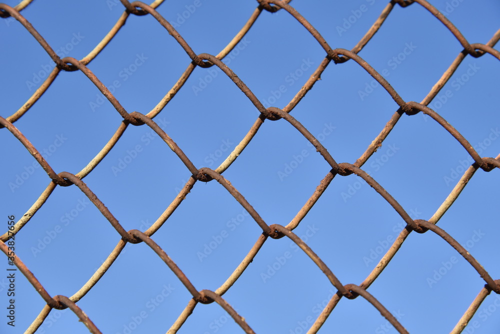 Fototapeta premium Metallic fence net against the sky