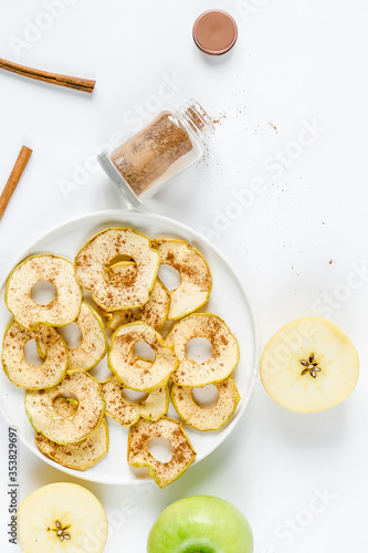 Chips from apples with cinnamon on a white background. Dried and fresh apples on a white background.
