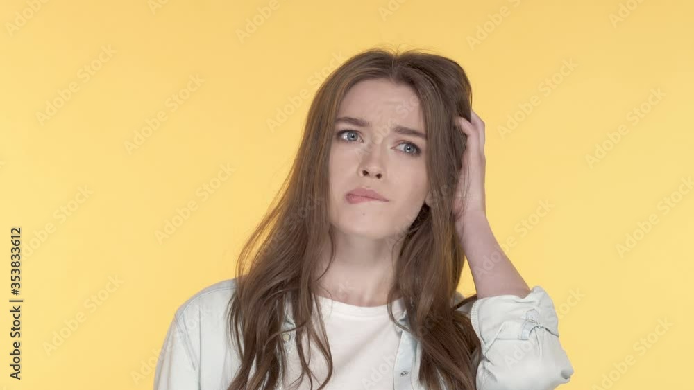 Close-up portrait of thoughtful young woman showing idea and finger up gesture. Yellow background. Close-up portrait of thoughtful young woman showing idea and finger up gesture. Yellow background.
