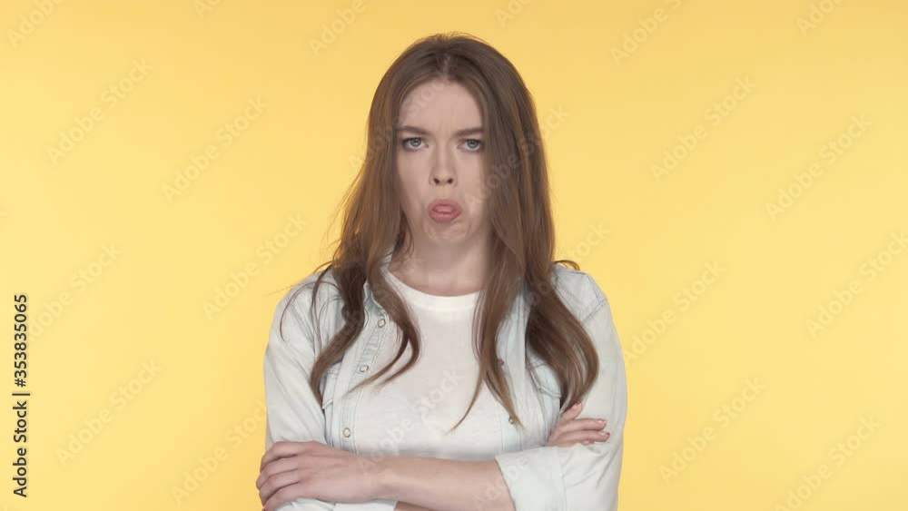 Portrait of unhappy young woman showing tonque. yellow background. Portrait of unhappy young woman showing tonque. yellow background.